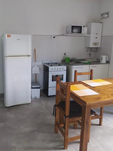 a kitchen with a table and a white refrigerator at Lo de Nora, ColónER in Colón