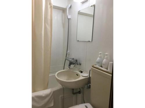 a bathroom with a sink and a toilet and a mirror at Kanku Sun Plus Yutaka - Vacation STAY 38984v in Izumi-Sano
