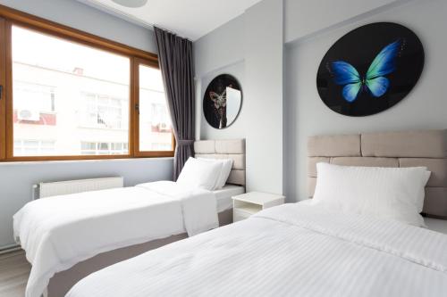2 camas en una habitación con mariposas en las paredes en Superhost! Bakirkoy, Shopping Malls and Cafes! en Estambul
