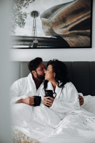 a man and a woman laying in bed kissing at Level Seattle Downtown - South Lake Union in Seattle