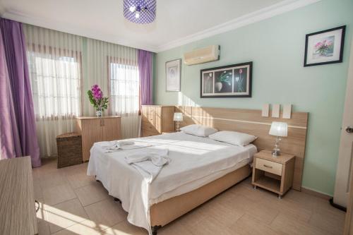 a bedroom with a large bed in a room at Villa Ersak Ölüdeniz in Fethiye
