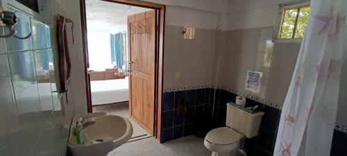 a bathroom with a toilet and a sink and a mirror at Casa Agua Bacalar / Naajil Ha in Bacalar