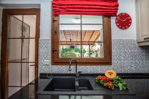 a kitchen with a sink and a window and a clock at Villa Ersak Ölüdeniz in Fethiye
