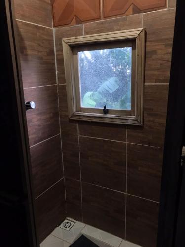 a bathroom with a window and a tiled shower at Sitio Holistico Natureza Sanadora in Morro Reuter