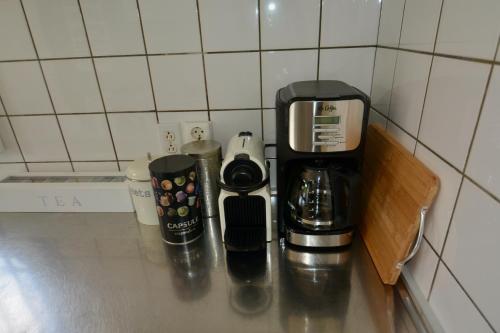 a coffeemaker and coffee cups sitting on a counter at The Julianadorp Villas in Willemstad