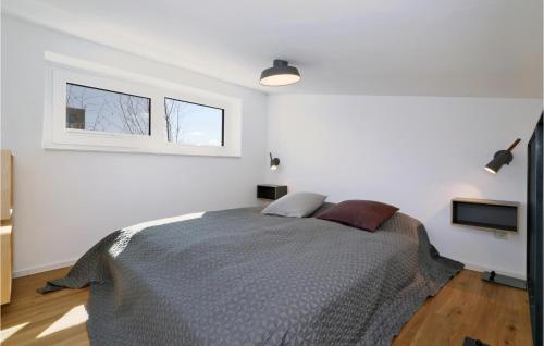 a white bedroom with a bed and a window at Beach Front Home In Lembruchdümmer See in Lembruch