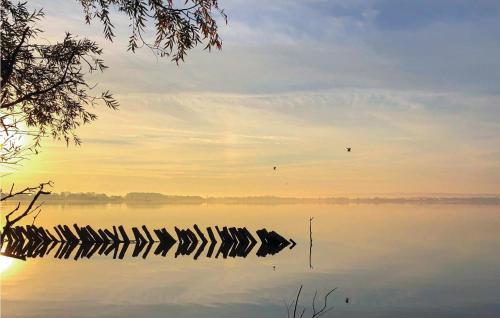 a group of rocks in the water at sunset at Beach Front Home In Lembruchdümmer See in Lembruch