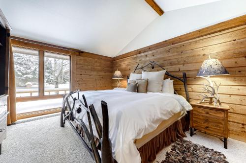 a bedroom with wooden walls and a bed and a window at Golf Creek12 in Teton Village