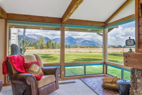 a living room with a large window with a view of the mountains at Golf Creek 32 in Teton Village