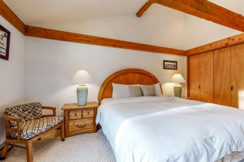 um quarto com uma cama grande e uma cadeira em Golf Creek 32 em Teton Village