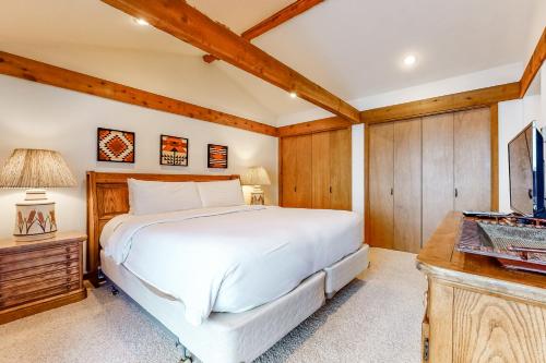 a bedroom with a large white bed and a desk at Golf Creek 32 in Teton Village