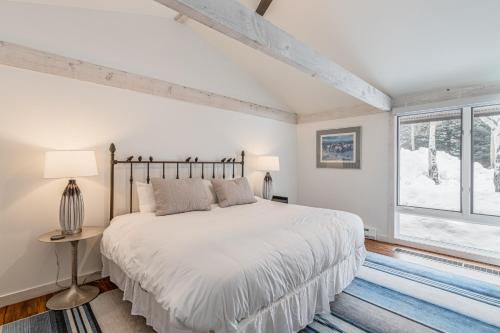 um quarto branco com uma cama e uma janela em Golf Creek 16 em Teton Village