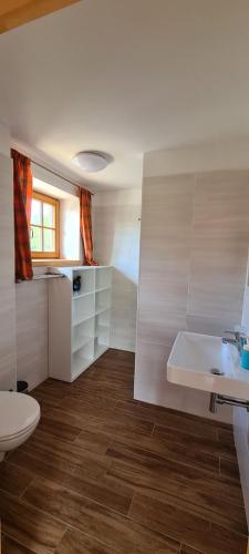 a white bathroom with a sink and a toilet at Chalupa Pod Větrným Vrchem in Dolní Morava