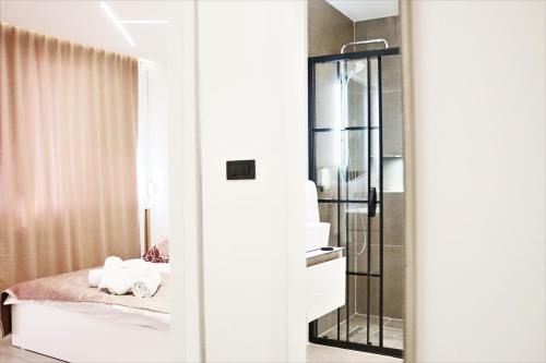 a bathroom with a bed and a glass shower at Matin Apartments in Pristina, Kosovo in Prishtinë
