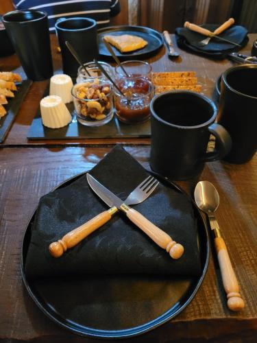 een houten tafel met een zwart bord, een vork en een mes bij Castelo de Portugraal in Vilela