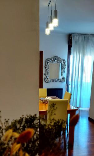 a dining room with a table and chairs and a mirror at Il sole in Carpi