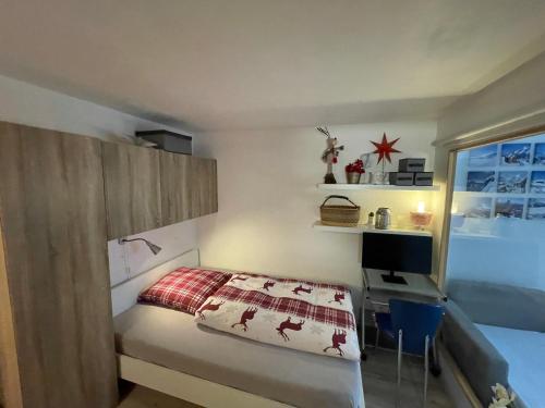 een slaapkamer met een bed, een bureau en een raam bij Ferienwohnung Gemmiblick in Leukerbad