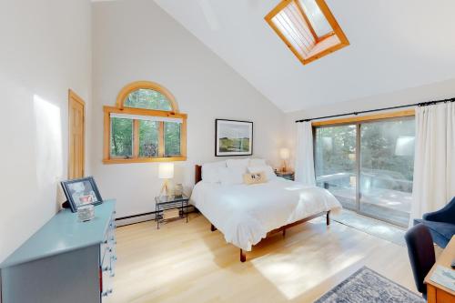 Schlafzimmer mit einem Bett, einem Schreibtisch und einem Fenster in der Unterkunft Stratton Hollow House in Forest Farms
