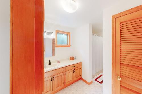 ein Bad mit einem Waschbecken und einem Spiegel in der Unterkunft Stratton Hollow House in Forest Farms