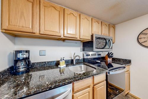 a kitchen with wooden cabinets and a sink at Center Village Hideaway in Frisco
