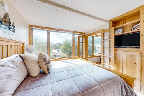 a bedroom with a large bed and a large window at Center Village Hideaway in Frisco