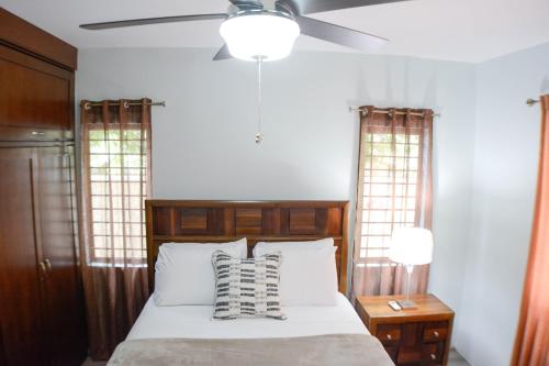 a bedroom with a bed with a ceiling fan at Pen Manor Modern 2 Bedroom Apartment in Boissiere Village