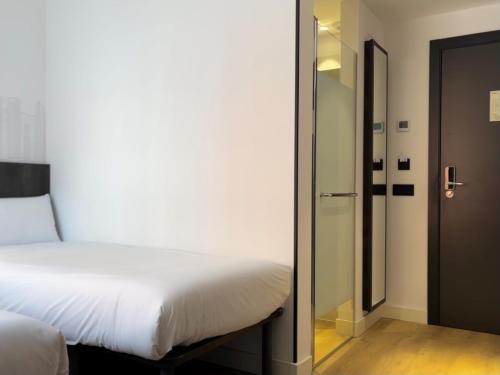 a bedroom with a bed and a sliding glass door at easyHotel Madrid Centro Atocha in Madrid