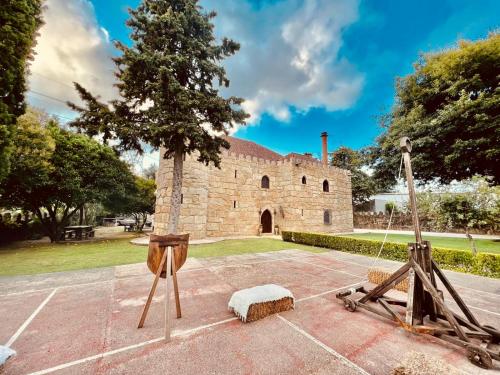 a stone building with two objects on display at Castelo de Portugraal in Vilela