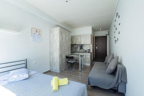 ein Schlafzimmer mit einem Bett und einem Sofa sowie eine Küche in der Unterkunft Modiano Studio ΙΙΙ By Socrates Junior Houses in Thessaloniki