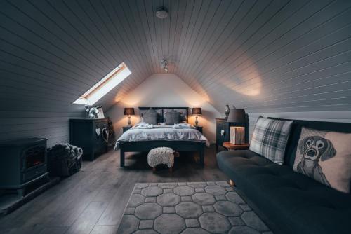 sypialnia na poddaszu z łóżkiem i kanapą w obiekcie Wood Fired Hot Tub & Pergola with Glass Balcony. w mieście Brecon