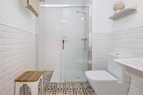 uma casa de banho branca com um chuveiro e um WC. em BHost - NIño Guevara em Málaga