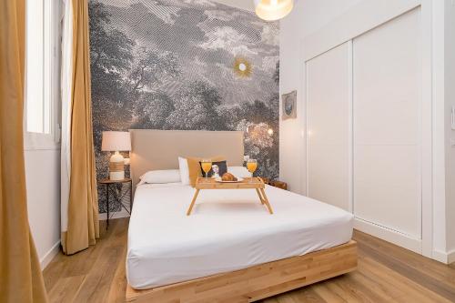 Un dormitorio con una cama con una mesa encima. en BHost - Niño Guevara, en Málaga