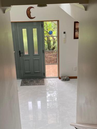 a green door in a room with a tile floor at Abel Tasman Marahau in Marahau