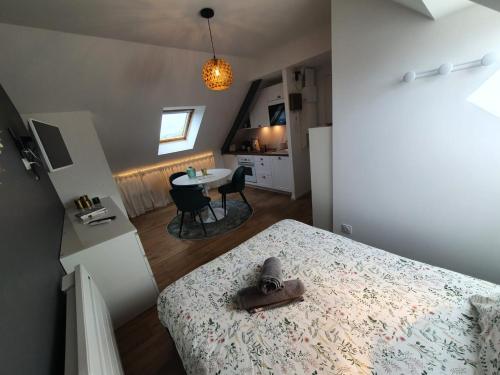 a small room with a bed and a table and a kitchen at La Palme d'Or by Madame Conciergerie in Bruz
