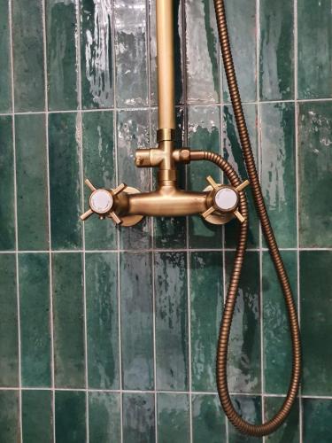 a copper pipe on a green tiled wall at La Palme d'Or by Madame Conciergerie in Bruz