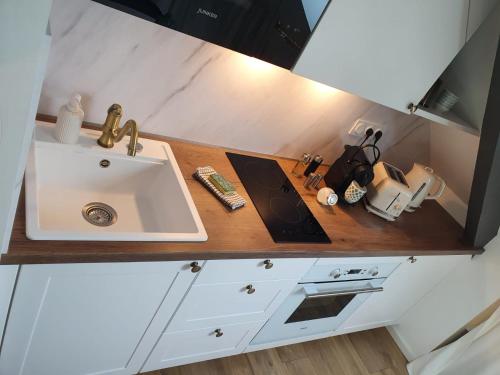a kitchen with a sink and a counter top at Le Cœur d’Artichaut by Madame Conciergerie in Bruz