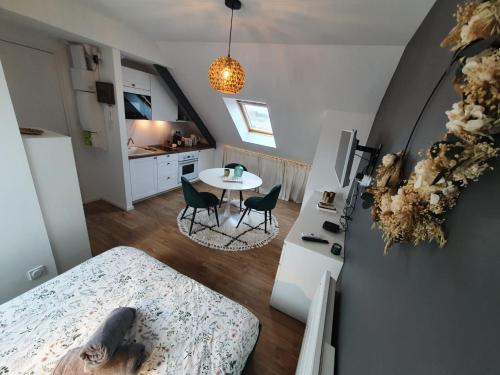 ein kleines Zimmer mit einem Tisch und einer Küche in der Unterkunft Le Cœur d’Artichaut by Madame Conciergerie in Bruz
