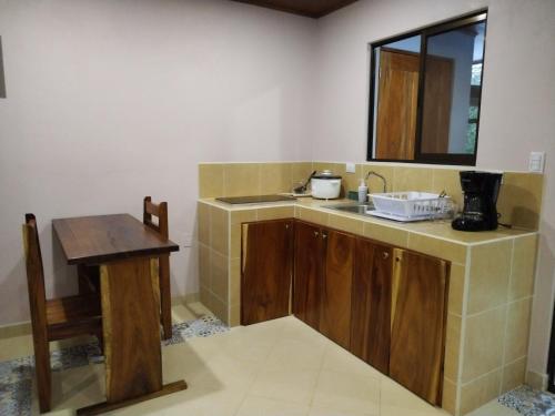 une petite cuisine avec un évier et une table dans l'établissement Habitación Equipada a 26 kilómetros de Jaco, Tulín Azul, 