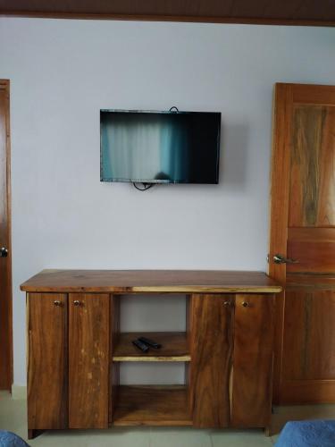 a wooden entertainment center with a television on a wall at Cabina equipada cerca de río y montañas Tulín Azul in Tulín