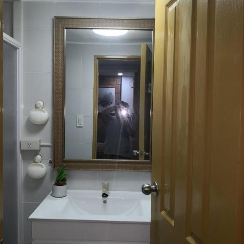a person taking a picture of a bathroom mirror at 426 Anabelle Residence at Marina Spatial Condominium in Dumaguete