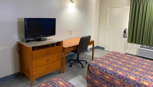 a hotel room with a desk with a television and a bed at Express Inn Newport News in Newport News