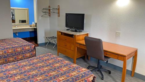 a room with a desk with a computer and a television at Express Inn Newport News in Newport News