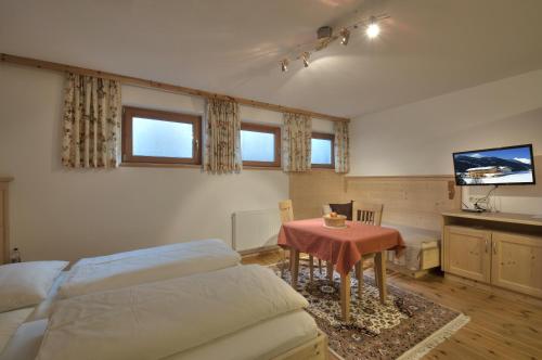 a bedroom with a bed and a table and a tv at Apart Ehart in Sankt Anton am Arlberg