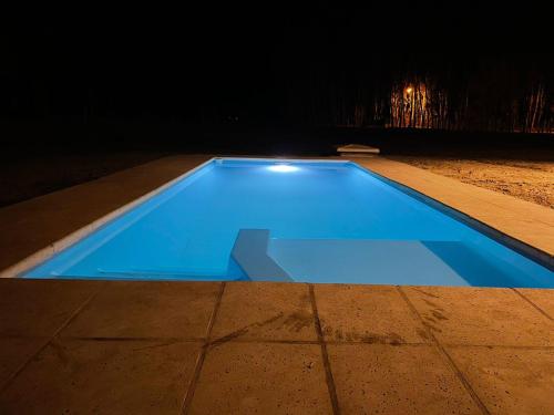 a blue swimming pool at night with at Casa Julia, Tunuyán in Colonia Las Rosas