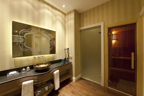 a bathroom with a sink and a large mirror at Kaya Palazzo Ski & Mountain Resort in Kartalkaya