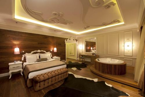 a bedroom with a large bed and a bath tub at Kaya Palazzo Ski & Mountain Resort in Kartalkaya