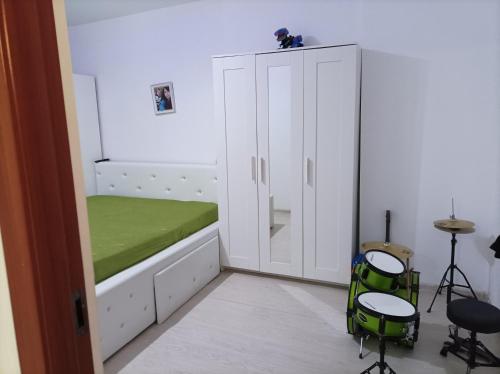 a small bedroom with a bed and two stools at Apartament două camere in Uricani