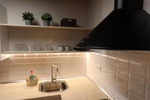 a kitchen with a sink and a black lamp at Casa Rural La Chiquitita in Alaejos