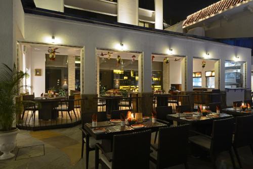 a restaurant with tables and chairs in a room at Sun-n-Sand Mumbai Juhu Beach in Mumbai