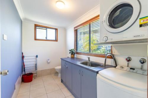 a small bathroom with a sink and a toilet at Baggies On Dutchies, 9 Burbong Street - Large Pet Friendly house with spectacular waterviews, Wi-Fi and air con in Nelson Bay